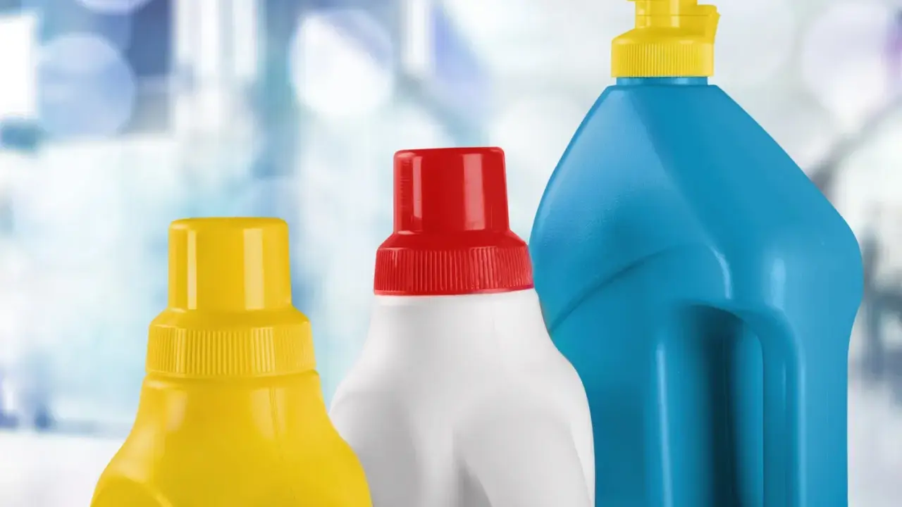 Tre flaconi di detergenti, uno giallo, uno bianco con tappo rosso e uno blu, pronti per la pulizia, forse anche per la candeggina in piscina.