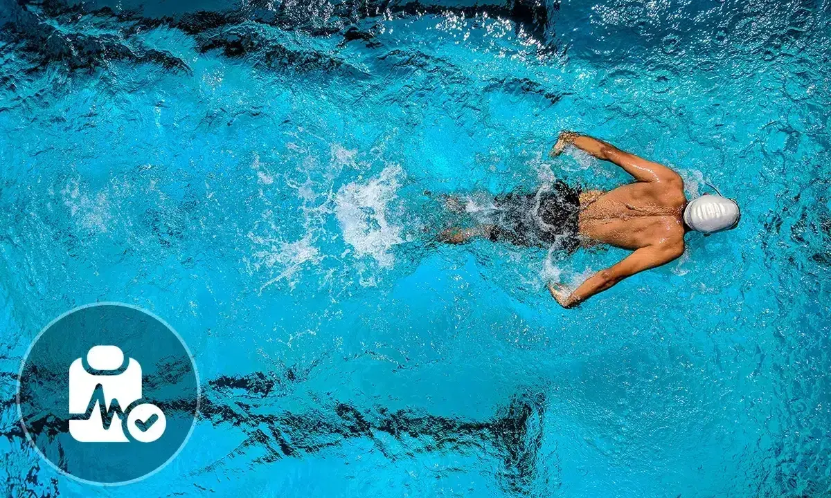 Nuotatore in piscina, con icona di controllo medico. Nonostante i benefici, ci sono anche svantaggi del nuoto da considerare.