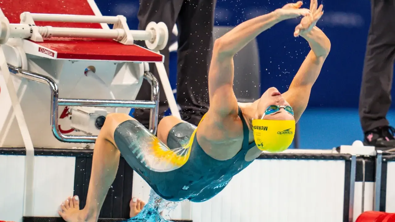 Kaylee McKeown si tuffa in piscina, con le braccia tese e il corpo inarcato, pronta a iniziare la sua gara.