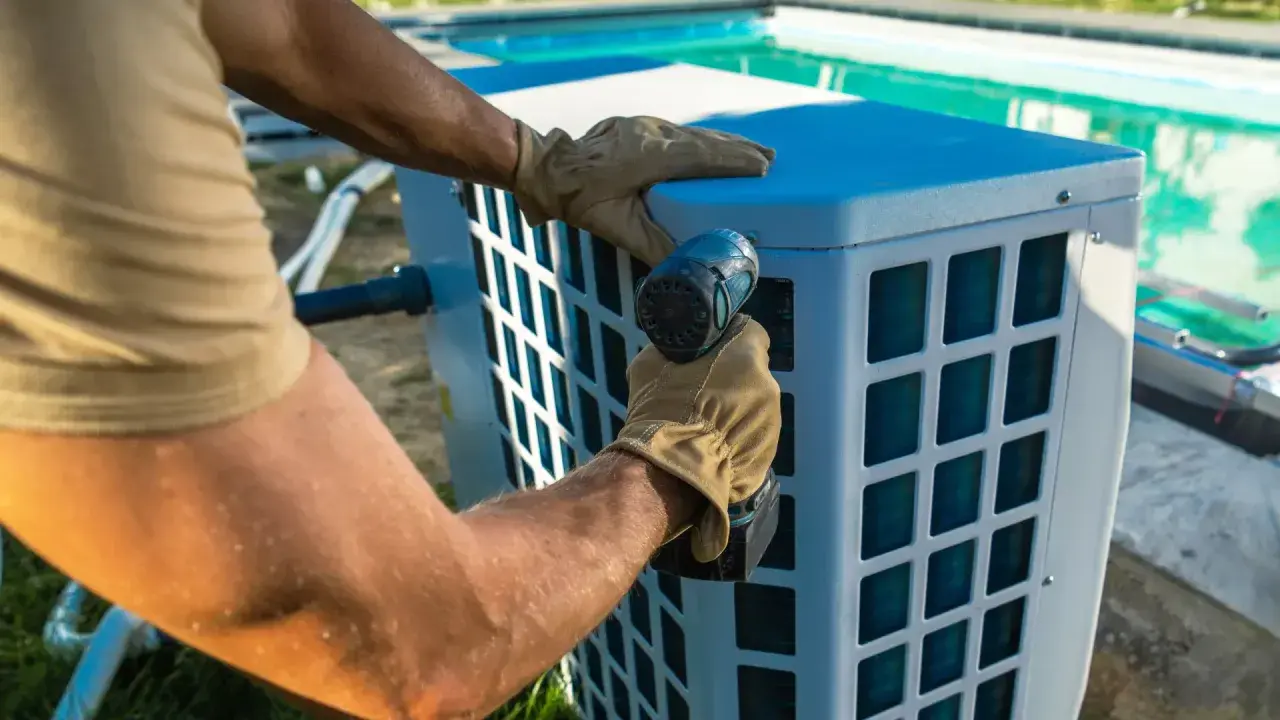 Installazione di un sistema per riscaldare acqua piscina fai da te. Un uomo con guanti avvita un componente.