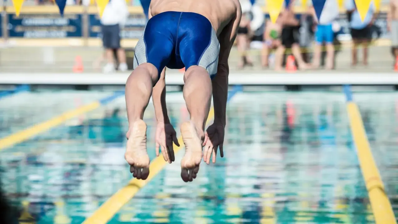 Nuotatore in partenza, dimostrazione dei benefici del nuoto a 50 anni.