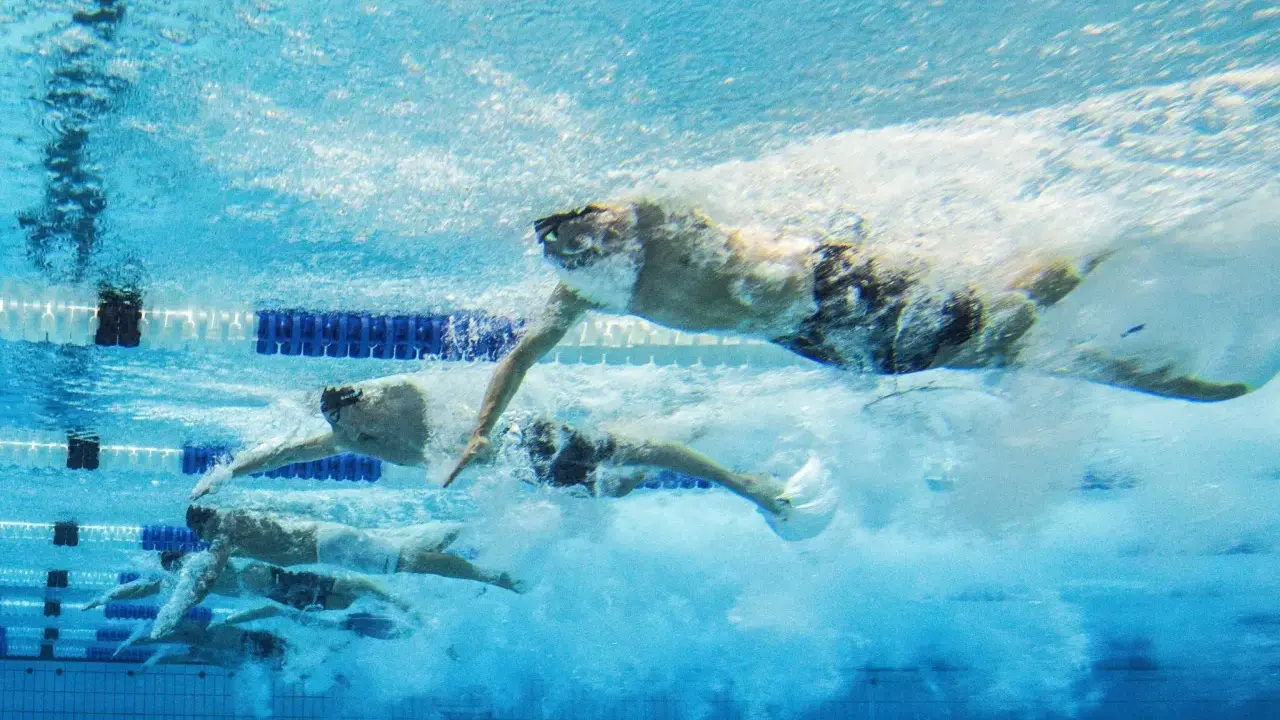 Nuotatori in azione, un allenamento nuoto principianti che mostra la determinazione e la tecnica sotto il pelo dell'acqua.