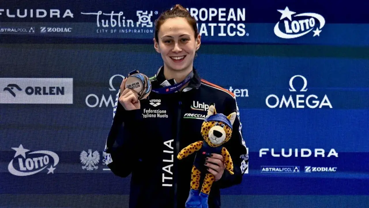 Anita Gastaldi sorride con una medaglia al collo e un peluche di ghepardo, celebrando una vittoria.