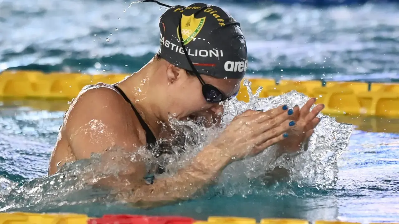 Arianna Castiglioni in azione, con schizzi d'acqua che la circondano durante una gara di nuoto.