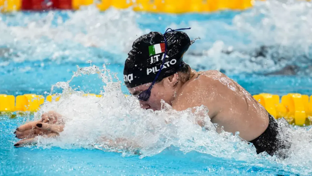 Chiara della Corte, nuotatrice italiana, in azione, con la bandiera tricolore sul costume.