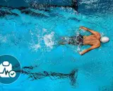 Nuotatore in piscina, con icona di controllo medico. Nonostante i benefici, ci sono anche svantaggi del nuoto da considerare.
