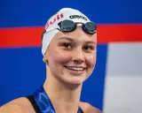 Sorriso raggiante di Summer McIntosh, nuotatrice con cuffia e occhialini, pronta per una gara.