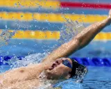 Michele Lamberti in azione, con il braccio teso e l'acqua che schizza, durante una gara di nuoto.