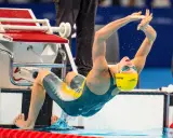 Kaylee McKeown si tuffa in piscina, con le braccia tese e il corpo inarcato, pronta a iniziare la sua gara.
