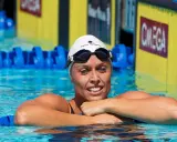 Amanda Beard, nuotatrice sorridente in piscina, con cuffia e occhialini, pronta per la gara.