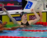 La nuotatrice Caterina Santambrogio esulta dopo una gara, con il braccio alzato e un sorriso sul volto.