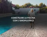 Uomo pulisce con idropulitrice il bordo di una piscina fuori terra.