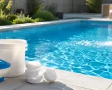 Prodotti per la piscina e un secchio blu che versa granuli nell'acqua. Mantenere l'alcalinità dell'acqua è fondamentale per il benessere della piscina.