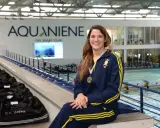 Rachele Ceracchi, nuotatrice sorridente con medaglia al collo, posa in un centro sportivo con piscina.