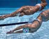Due nuotatori si allenano in piscina, un uomo e una donna, in un intenso allenamento ipossico.