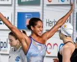 Atleta festeggia vittoria nel nuoto, braccia alzate con gioia.