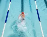 Nuotatore in corsia, godendosi i benefici del nuoto libero. L'acqua cristallina e il movimento fluido del corpo evidenziano la libertà e il benessere.