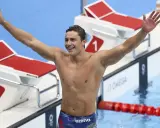 Il nuotatore Nicolò Martinenghi, con il suo fisico scolpito, esulta con le braccia alzate dopo una gara.