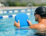 Uomo in piscina con tavoletta blu, pronto per il nuoto con tavoletta per dimagrire.