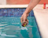 Mano immerge kit test pH nell'acqua della piscina, per assicurarsi che non sia acqua viscida.