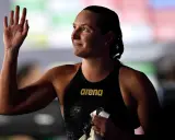 Katinka Hosszu, bagnata e sorridente, saluta con la mano dopo una gara.