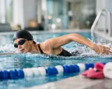 Donna nuota in piscina, bruciando calorie. Allenamento intenso per 30 vasche nuoto calorie.