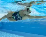 Donna nuota in piscina, parte di un programma di nuoto per dimagrire.