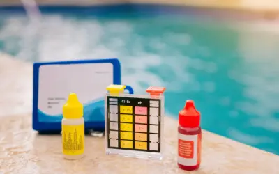 Kit per testare il cloro e il ph della piscina, con boccette di reagenti e strisce colorate.