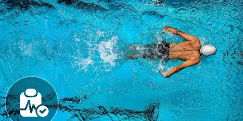 Nuotatore in piscina, con icona di controllo medico. Nonostante i benefici, ci sono anche svantaggi del nuoto da considerare.