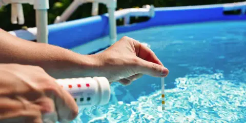 Controllo del livello dell'acqua della piscina con strisce reattive. L'abbassamento del livello dell'acqua è normale in estate.