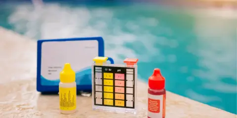 Kit per testare il cloro e il ph della piscina, con boccette di reagenti e strisce colorate.