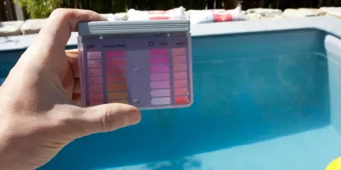 Test kit per piscina mostra pH alto. Per abbassare alcalinità piscina, controlla i valori e agisci.
