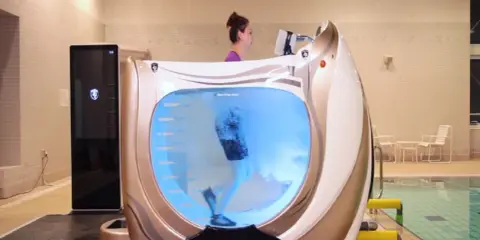 Donna corre su un tapis roulant in acqua, un modo efficace per dimagrire e tonificare il corpo.