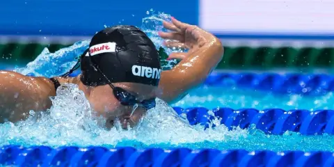 Stefania Pirozzi in azione, nuotando con determinazione. L'acqua schizza mentre si immerge per la prossima bracciata.