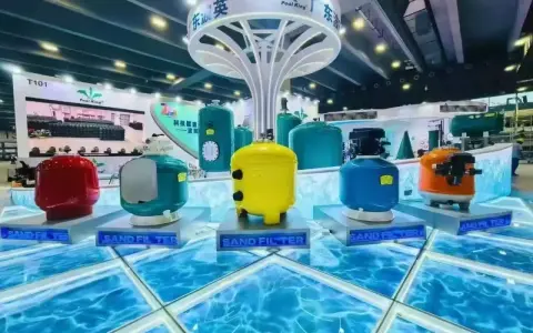 Filtri per piscina colorati, tra cui un giallo brillante, un blu acceso e un rosso vivace, esposti su una piattaforma che simula l'acqua. Questi filtri a sabbia sono essenziali per mantenere l'acqua cristallina.