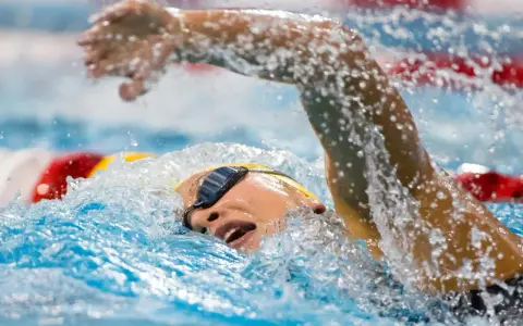 Nuotatore in azione, con la testa fuori dall'acqua per respirare. Un esempio di come allenare il fiato per migliorare le prestazioni in piscina.