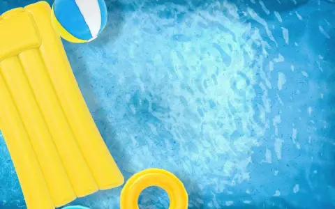 Un materassino giallo, una palla e un salvagente galleggiano in una piscina azzurra. Ideale per scoprire come pulire piscina gonfiabile.