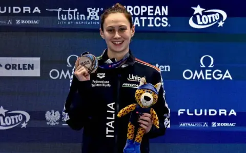 Anita Gastaldi sorride con una medaglia al collo e un peluche di ghepardo, celebrando una vittoria.