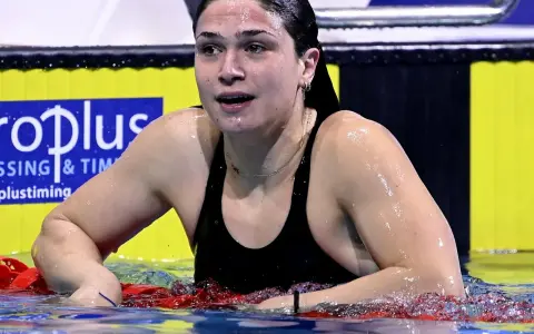 Benedetta Pilato, giovane campionessa di nuoto, emerge dall'acqua dopo una gara. La sua età non limita la sua forza.