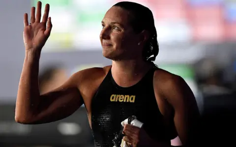 Katinka Hosszu, bagnata e sorridente, saluta con la mano dopo una gara.