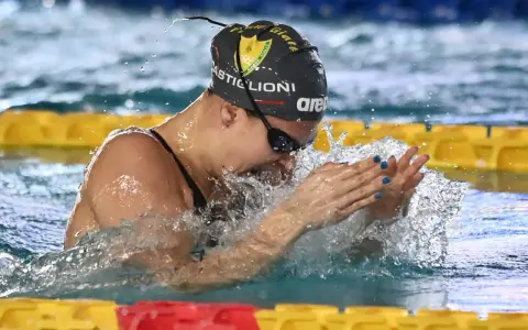Arianna Castiglioni in azione, con schizzi d'acqua che la circondano durante una gara di nuoto.