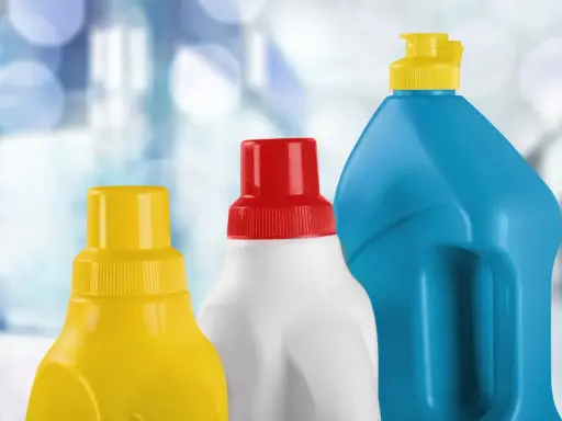 Tre flaconi di detergenti, uno giallo, uno bianco con tappo rosso e uno blu, pronti per la pulizia, forse anche per la candeggina in piscina.