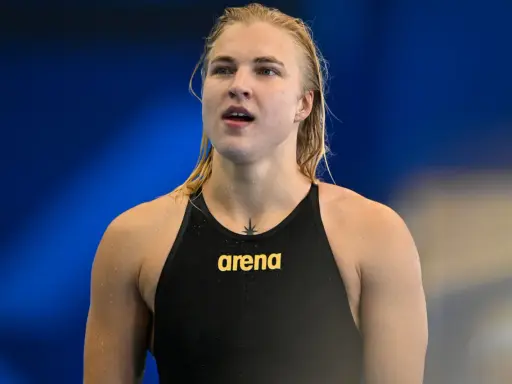 Rūta Meilutytė, nuotolinė plaukikė, su vandens lašeliais ant odos, pasirengusi varžyboms.