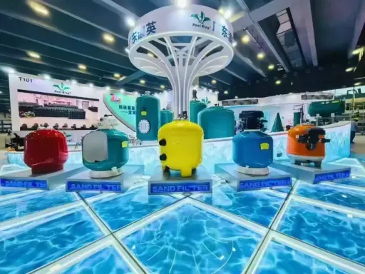 Filtri per piscina colorati, tra cui un giallo brillante, un blu acceso e un rosso vivace, esposti su una piattaforma che simula l'acqua. Questi filtri a sabbia sono essenziali per mantenere l'acqua cristallina.