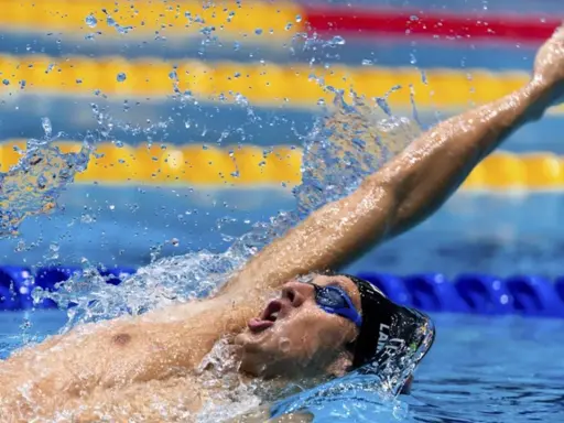 Michele Lamberti in azione, con il braccio teso e l'acqua che schizza, durante una gara di nuoto.