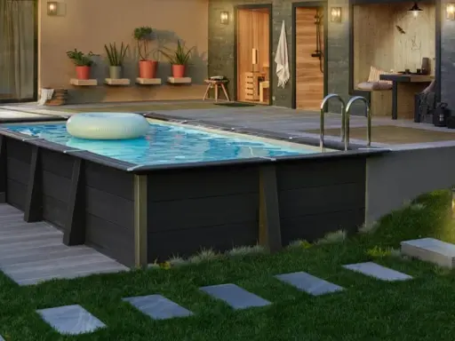 Piscina fuori terra con bordo in legno scuro, ideale per idee piscine fai da te. Un anello gonfiabile galleggia sull'acqua.