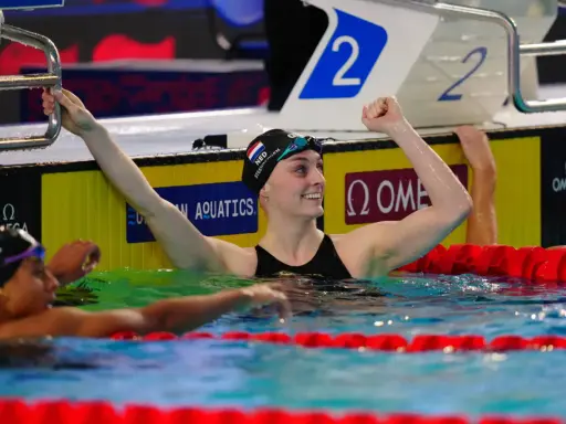 La nuotatrice Caterina Santambrogio esulta dopo una gara, con il braccio alzato e un sorriso sul volto.