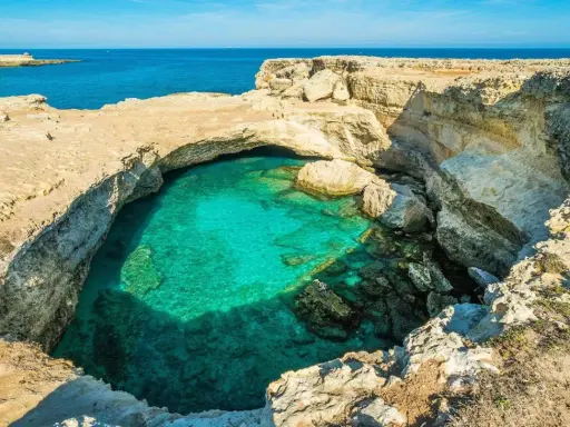 Splendide piscine naturali Sicilia, con acqua cristallina che invita al relax tra le rocce dorate.