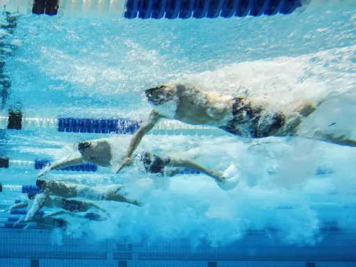 Nuotatori in azione, un allenamento nuoto principianti che mostra la determinazione e la tecnica sotto il pelo dell'acqua.