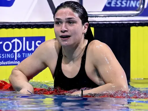 Benedetta Pilato, giovane campionessa di nuoto, emerge dall'acqua dopo una gara. La sua età non limita la sua forza.